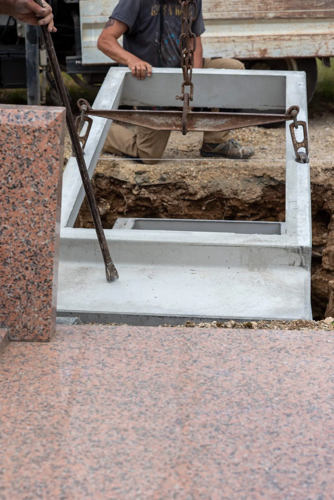 Pose d'un caveau funéraire en béton par un marbrier au cimetière